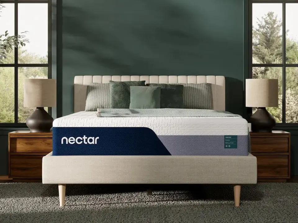 Memory foam mattress on an upholstered bed in a dark green bedroom